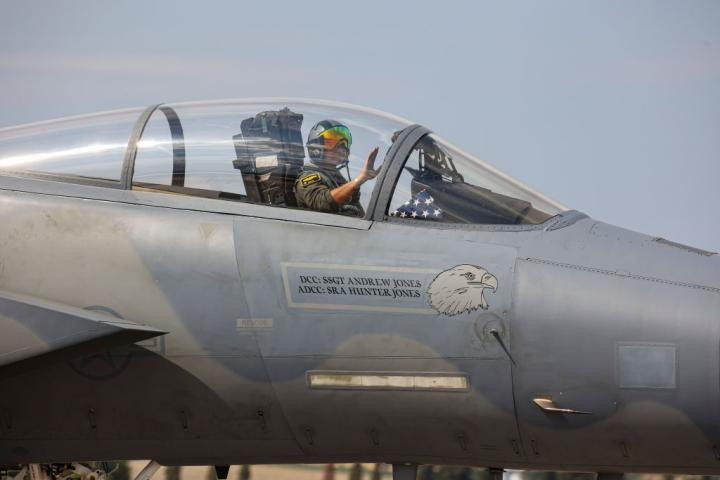 Un soldado estadounidense saluda desde un caza F-15 Eagle.