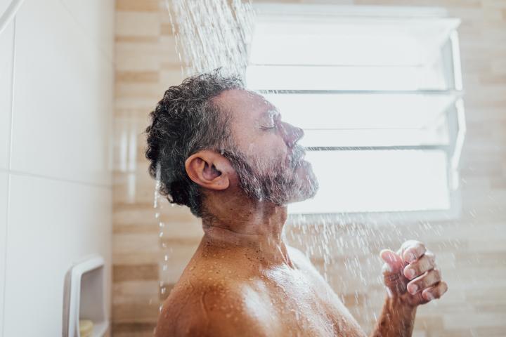 Un hombre dándose una ducha.