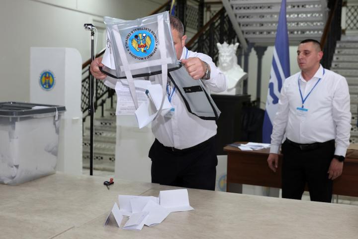 Un miembro de una mesa electoral procede al recuento de votos en las elecciones presidenciales y el referéndum por la adhesión de Moldavia a la Unión Europea.