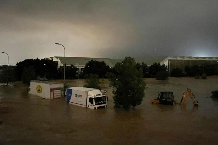 Camiones y un vehículo de construcción parcialmente sumergidos en las inundaciones que han tenido lugar en la provincia de Valencia