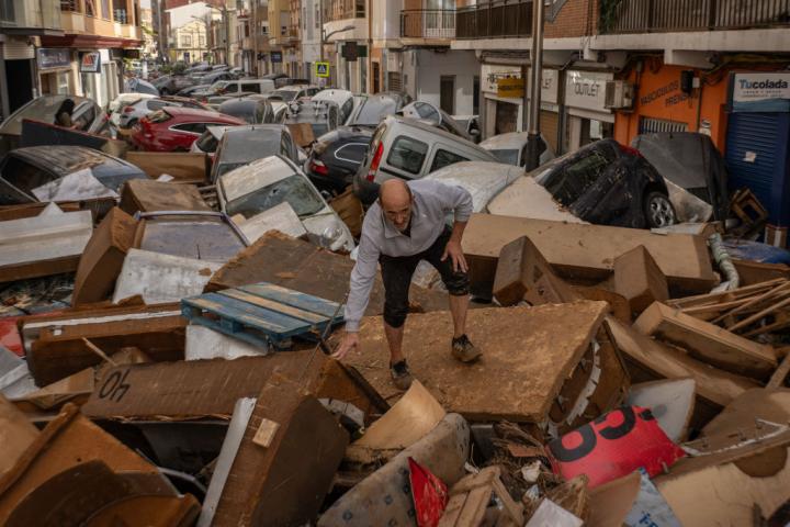 Un hombre camina por una calle de Utiel cubierta de escombros después de que las inundaciones repentinas provocadas por el paso de una DANA.