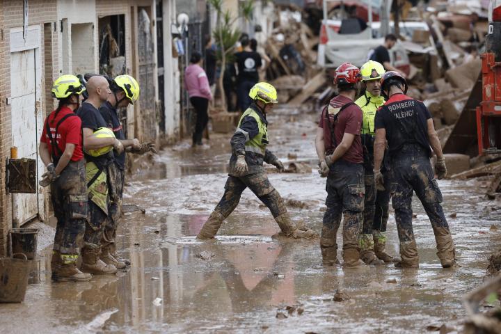 Efectivos del cuerpo de bomberos trabajan en la limpieza y retirada del lodo en Alfafar (Valencia).