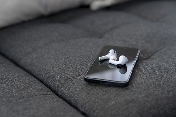 Imagen de archivo de un teléfono móvil con unos auriculares inalámbricos.