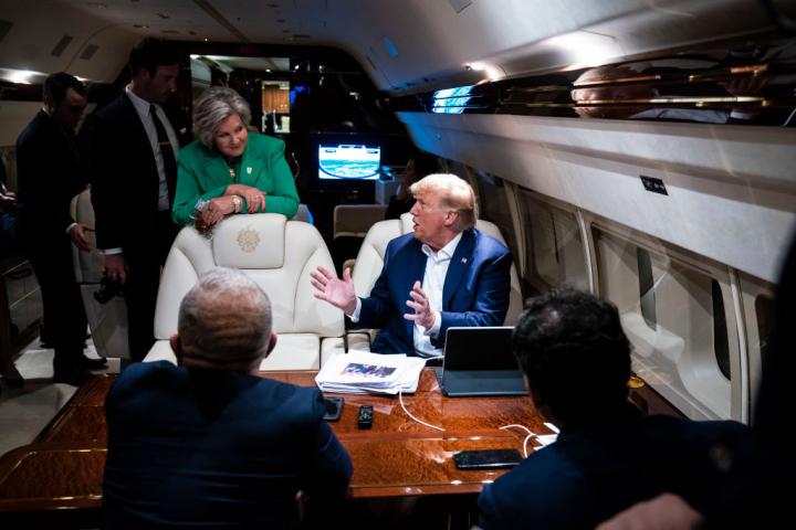 Susie Wiles, de verde, habla con Donald Trump en una reunión a bordo del 'Trump Force One'