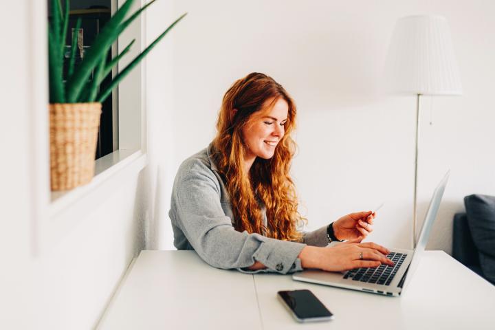Una mujer usa su tarjeta de crédito para hacer unas compras.