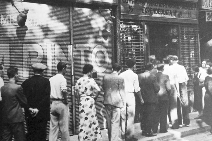 Unos ciudadanos recogen sus cartas de racionamiento en una calle de Barcelona, en 1937, plena Guerra Civil Española.
