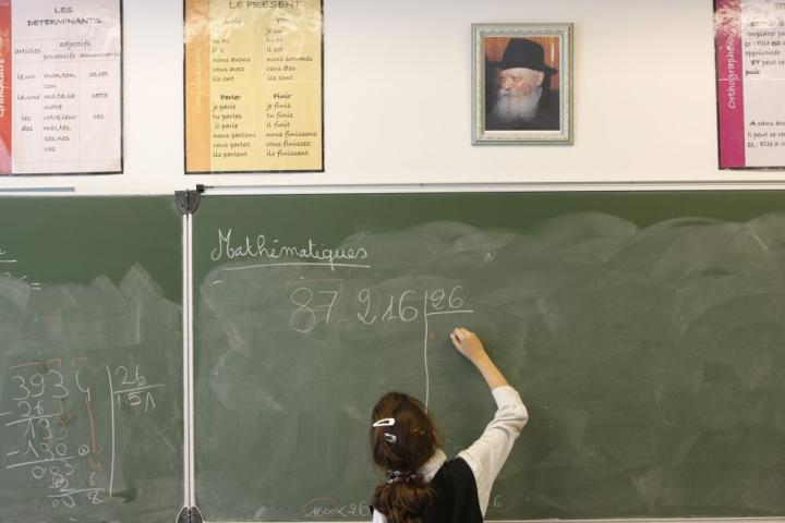 Una niña pinta en la pizarra de un colegio en Francia.