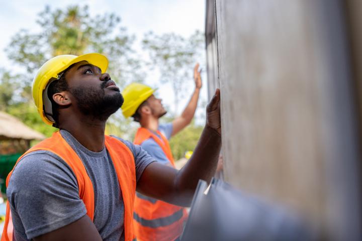 Imagen de archivo de trabajadores levantando una casa prefabricada.
