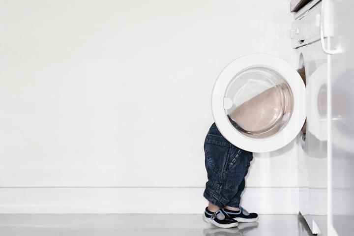 Imagen de archivo de un niño y una lavadora.