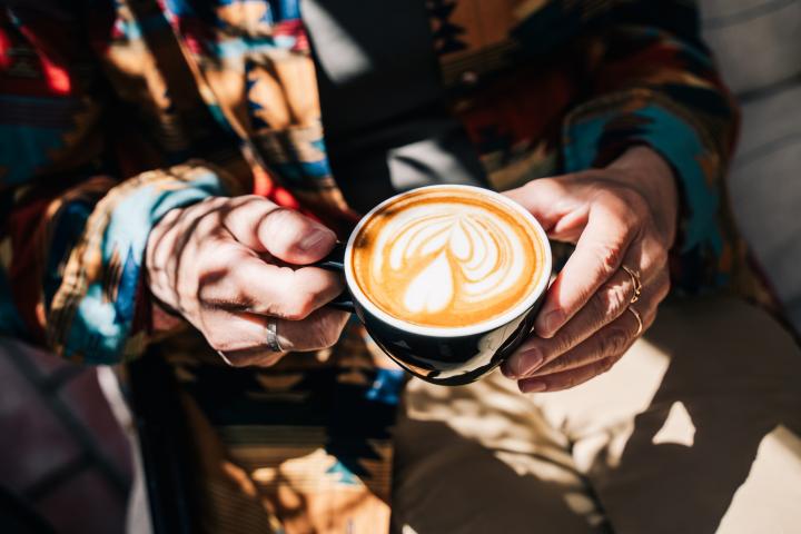 Una mujer sosteniendo un café.