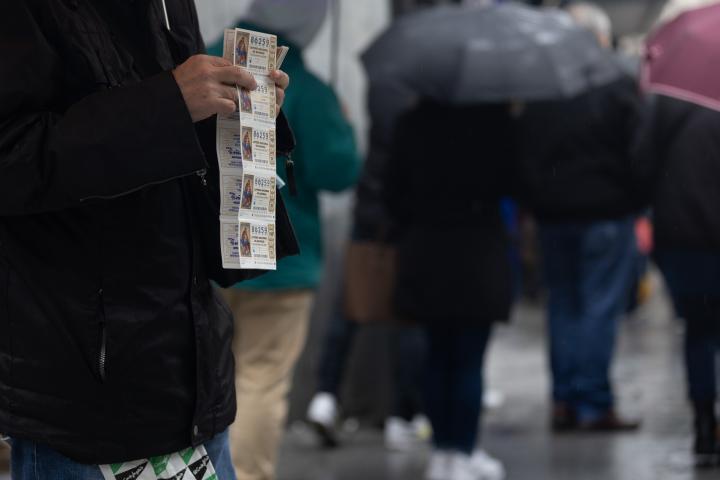 Una mujer vendiendo décimos de la Lotería de Navidad.
