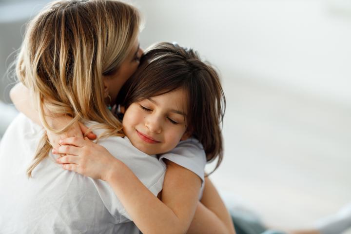 Imagen de archivo de una niña abrazando a su madre.