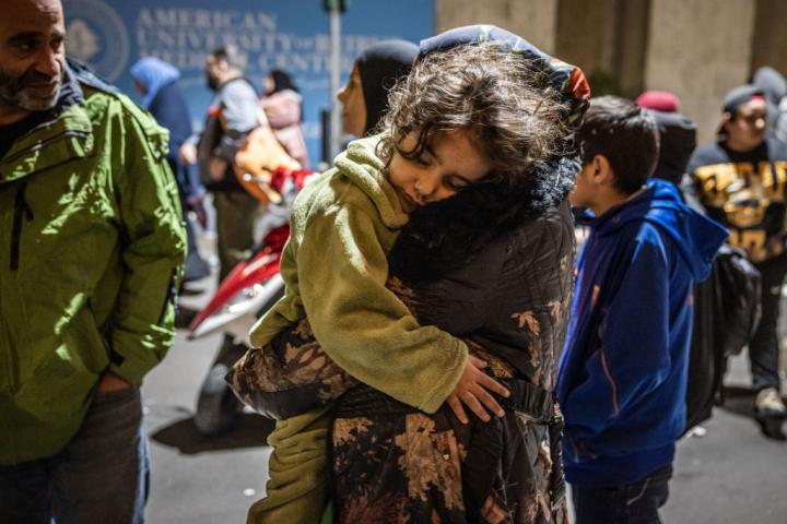 Una mujer lleva en brazos a una niña mientras los desplazados en Líbano emprenden un regreso a casa.