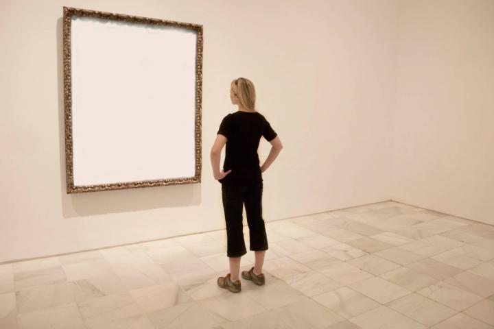 Mujer observa un cuadro vacio