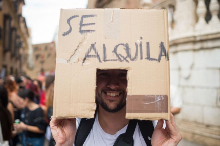 Un manifestante lleva una caja que representa una casa en alquiler en una manifestación en Málaga exigiendo una vivienda digna.