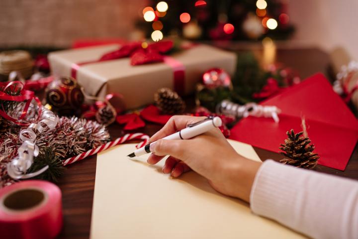 Imagen de una persona que se dispone a escribir una tarjeta navideña.