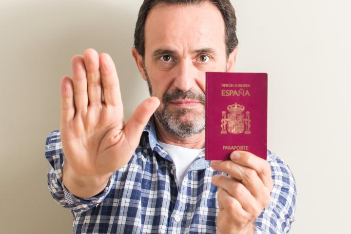 Imagen de un hombre mostrando un pasaporte español.