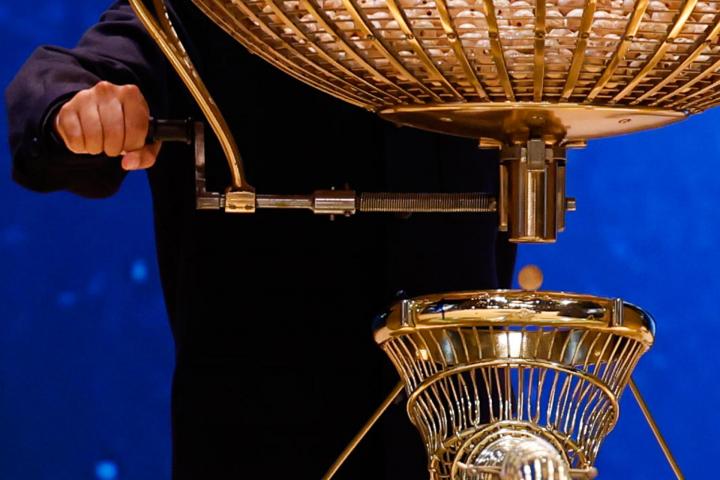 Un niño de San Ildenfonso extrae una bola de un bombo durante el sorteo de la Lotería de Navidad