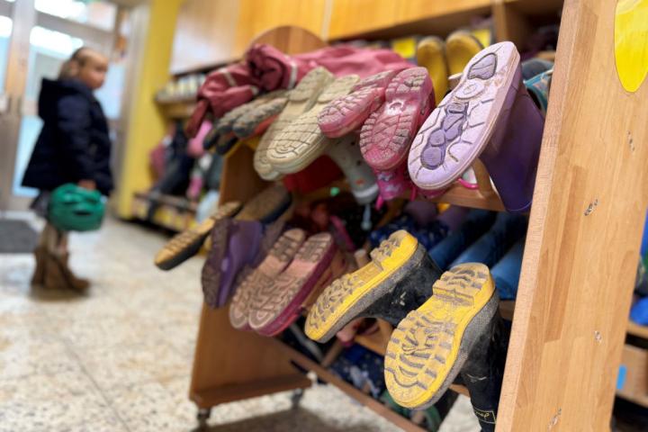 Entrada de una guardería donde hay un puesto para botas de goma.