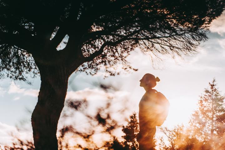 Una mujer, junto a un árbol