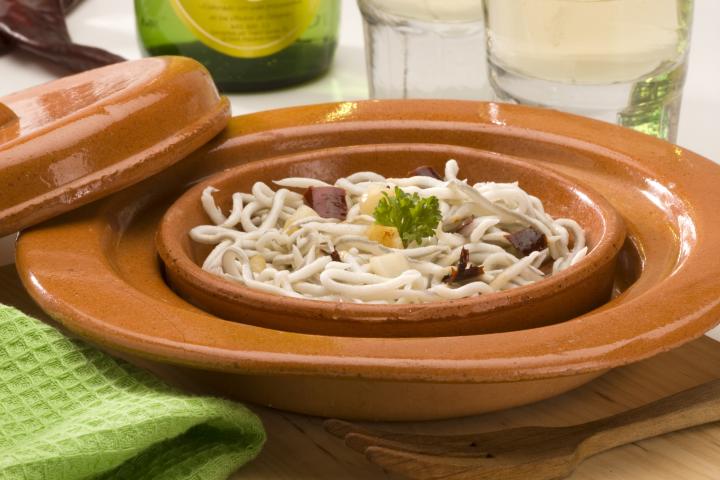 Plato de angulas en cazuela de barro.