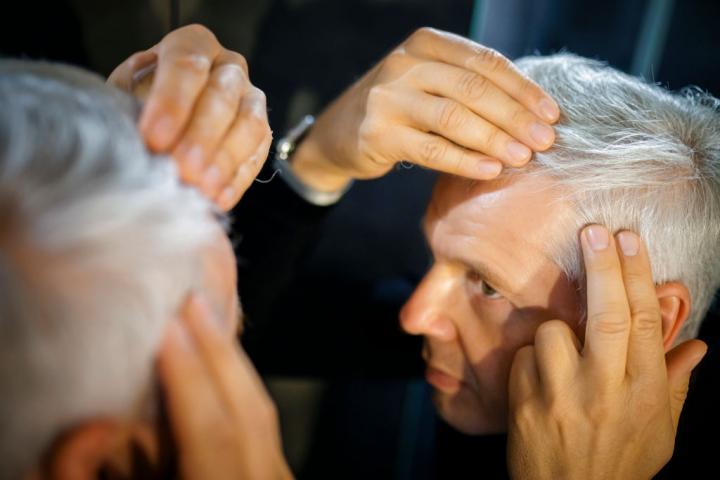 Un hombre se mira las arrugas en una foto de recurso