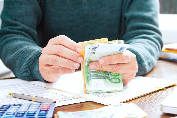 Imagen de una persona contando billetes de euro.