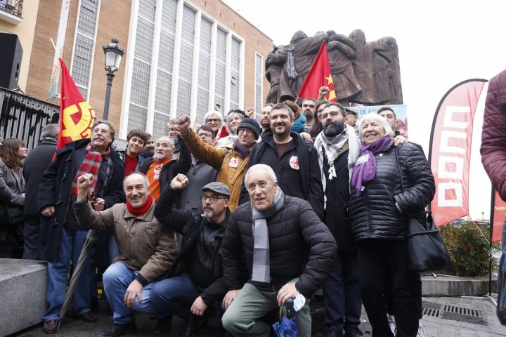 Una delegación del PCE posa junto a la estatua 'El Abrazo' del pintor y escultor Juan Genovés, en la plaza Antón Martín de la capital, en el homenaje este viernes a los cinco abogados de Atocha asesinados en 1977 en el despacho laboralista de la madrileña calle de Atocha, 55.