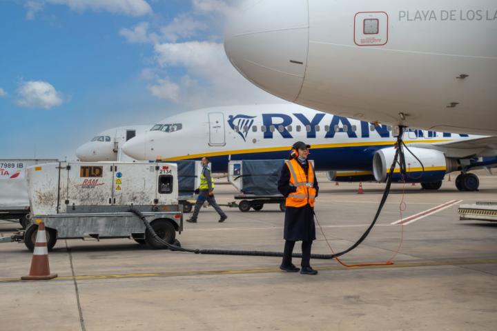 Una operaria llena de combustible un avión