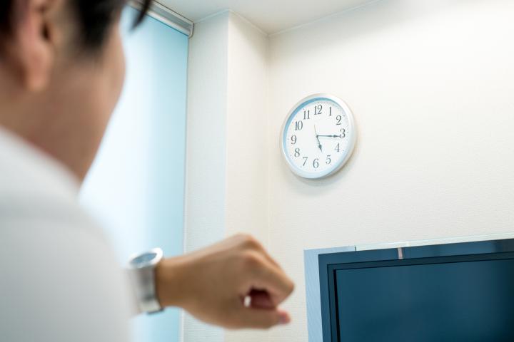 Imagen de un trabajador en una oficina observando el tiempo que resta de jornada laboral.