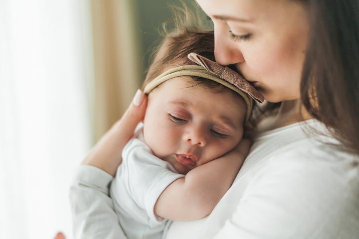 Una madre con su hija en brazos.