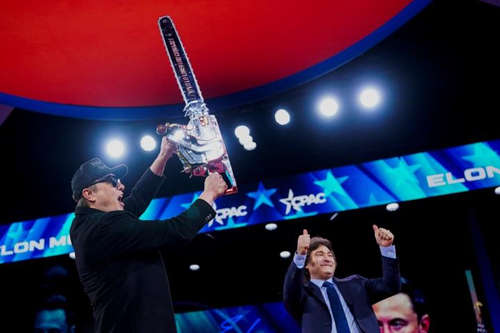 Elon Musk levanta la motosierra que le ha regalado Javier Milei en la CPAC ultra.