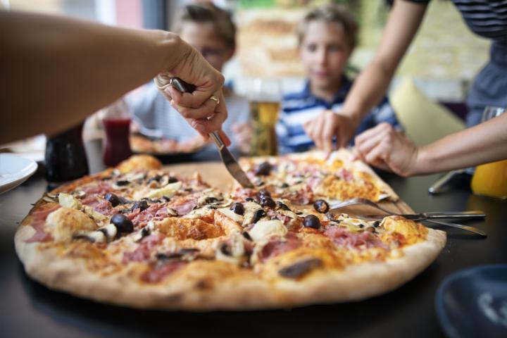 Foto de archivo de un grupo de amigos comiendo pizza.