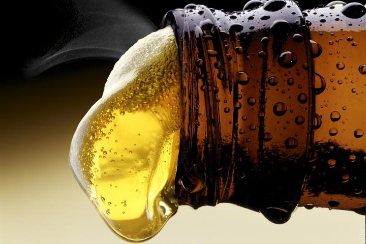 Imagen de un detalle de un tercio de cerveza recién abierto.