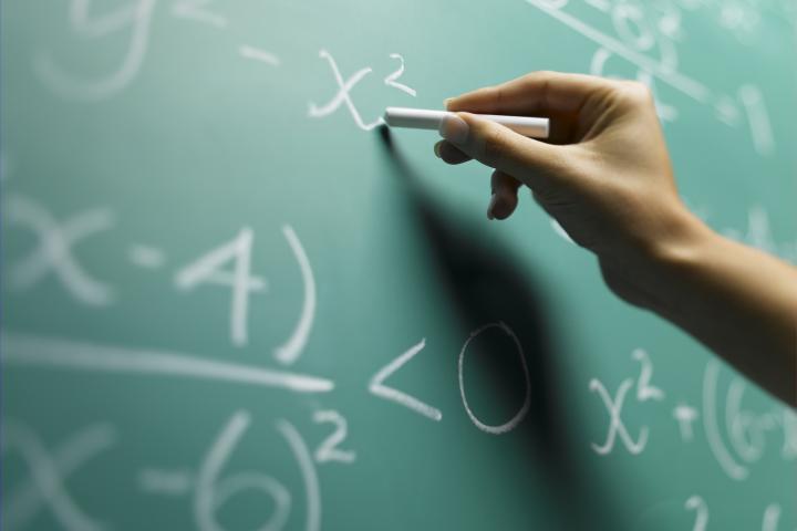 Imagen de archivo de una persona escribiendo sobre una pizarra.