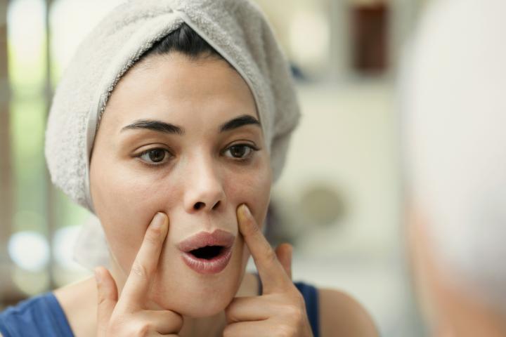 Una mujer haciendo yoga facial.