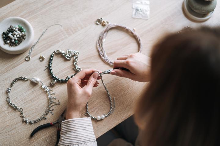 Una mujer, creando piezas de joyería en su estudio