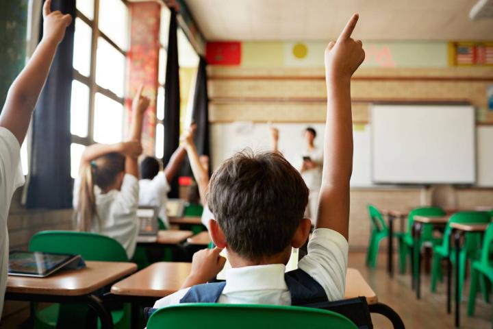 Niño levantando la mano en clase