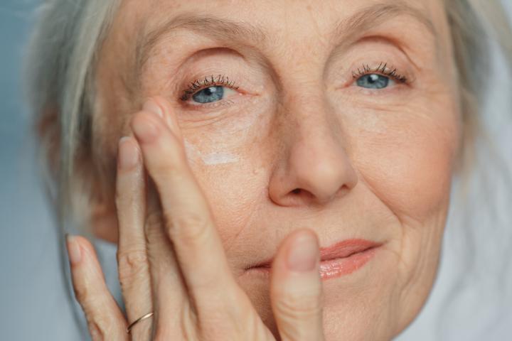 Una mujer aplicándose una crema.