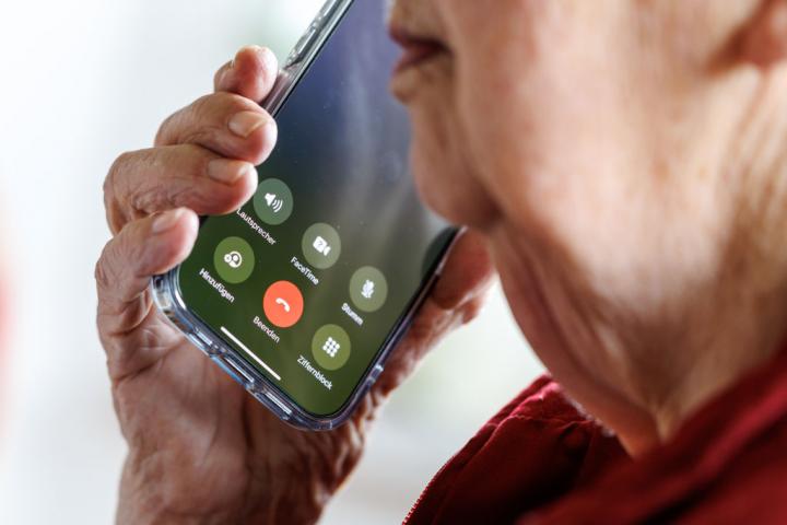 Una mujer de 90 años responde una llamada en su teléfono móvil.