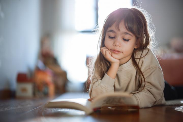 Una niña leyendo.