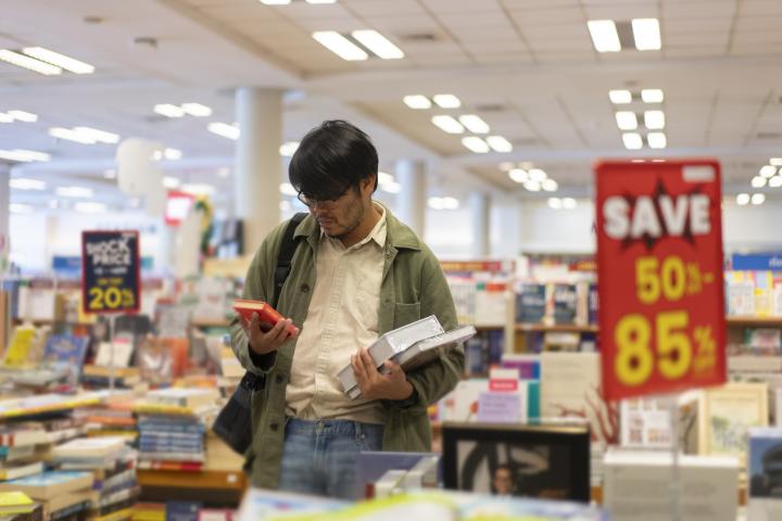 Un hombre ojea libros en una librería.