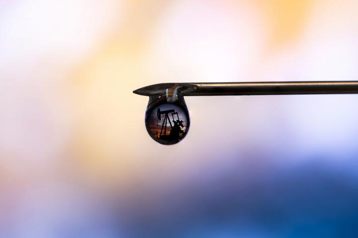 Ilustración de una refinería reflejada en una gota de petróleo.