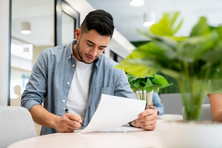 Un hombre firmando un documento.