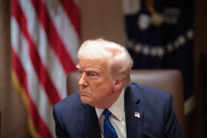 Donald Trump, con gesto serio, escuchando a alguien en la Casa Blanca