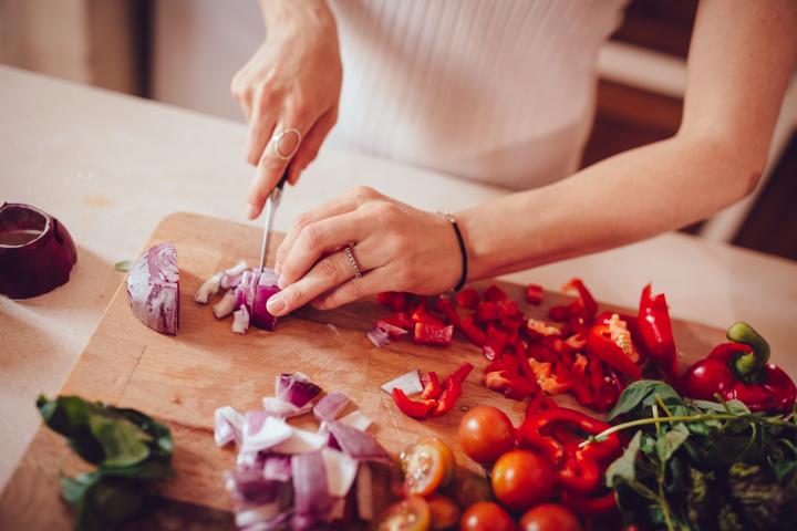 Mujer cocinando un plato con verduras