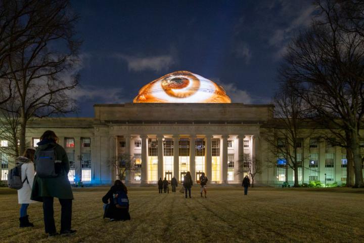 La cúpula del Instituto Tecnológico de Massachusetts, iluminada con proyecciones de del proyecto "Mirar a las Estrellas" del Grupo de Materia Crítica del Media Lab del MIT.