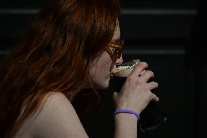 Imagen de archivo de una joven tomándose una cerveza Guinness en Dublín, Irlanda.