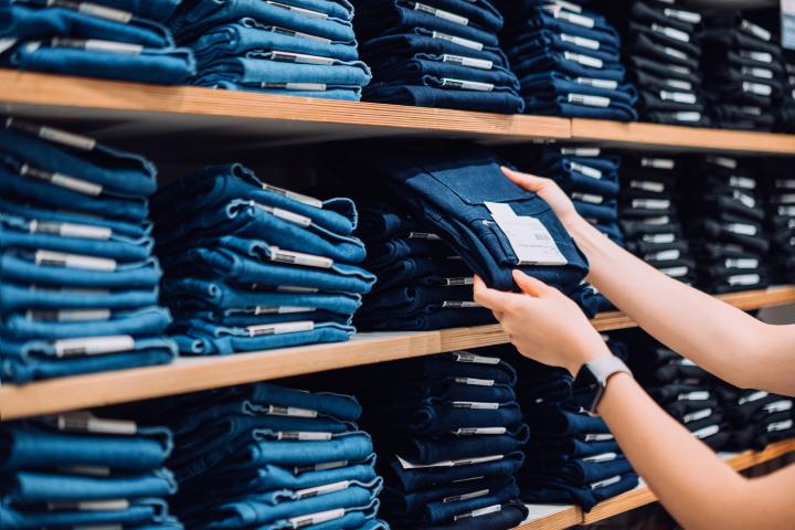 Imagen de una persona comprando vaqueros en una tienda de ropa.