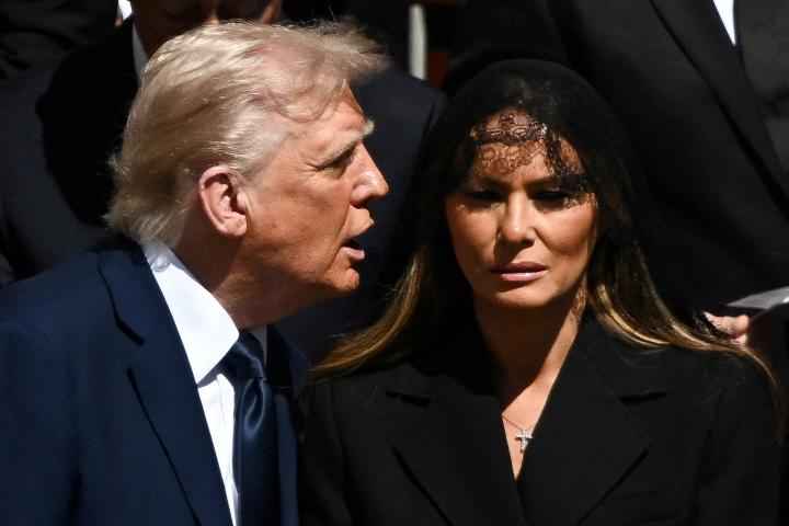 El presidente de Estados Unidos, Donald Trump, habla con su mujer, Melania, en el funeral del papa Francisco.